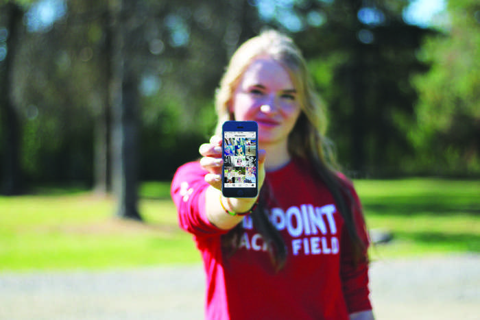 Grace Meyer holds a phone showing results for a #flipsideofme search on Instagram. 