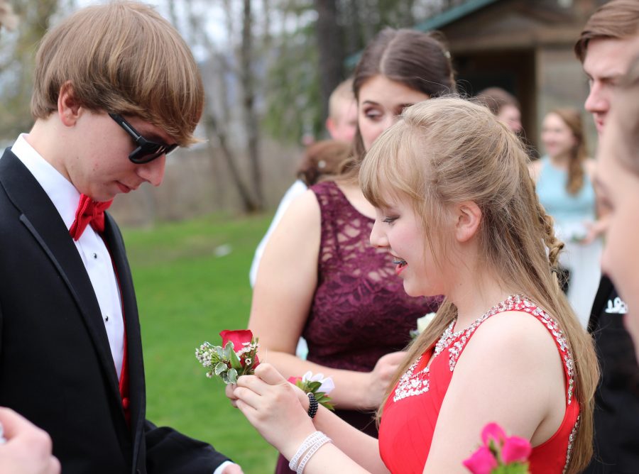 Junior Maya Roberts pins a boutineer on her date senior Mike Frei, who attends Sandpoint High. 