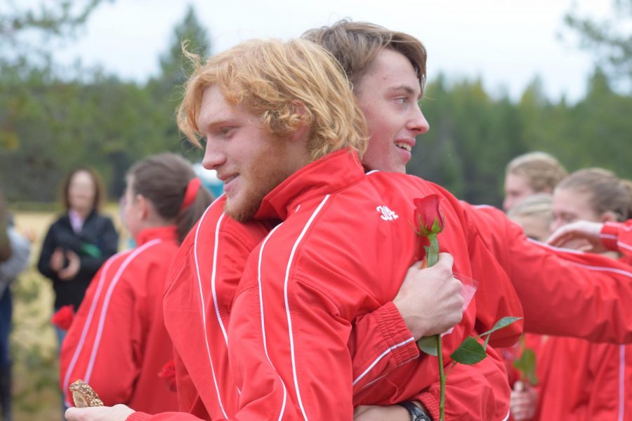 Peik Lund Andresen (right) hugs teammate Dutt Rogers (left) after all of the seniors on Cross Country are handed a rose for their four years of running. 