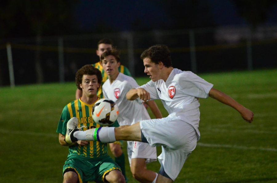 Senior Gage Sigman fights to keep the ball away from two Lakeland players. 