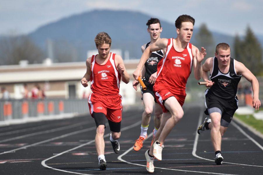 Junior Tyren Witthaus (left) and Senior Ammon Ollerton (right) hand the baton off during the 4*200 meter relay. 