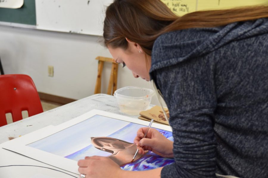 Senior Kelda Rial paints a picture for the art showcase.
