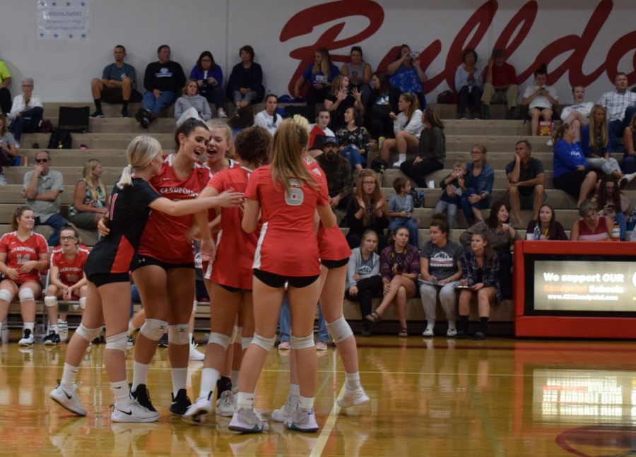 Varsity volleyball team celebrates a scored point against Lake City earlier this season.