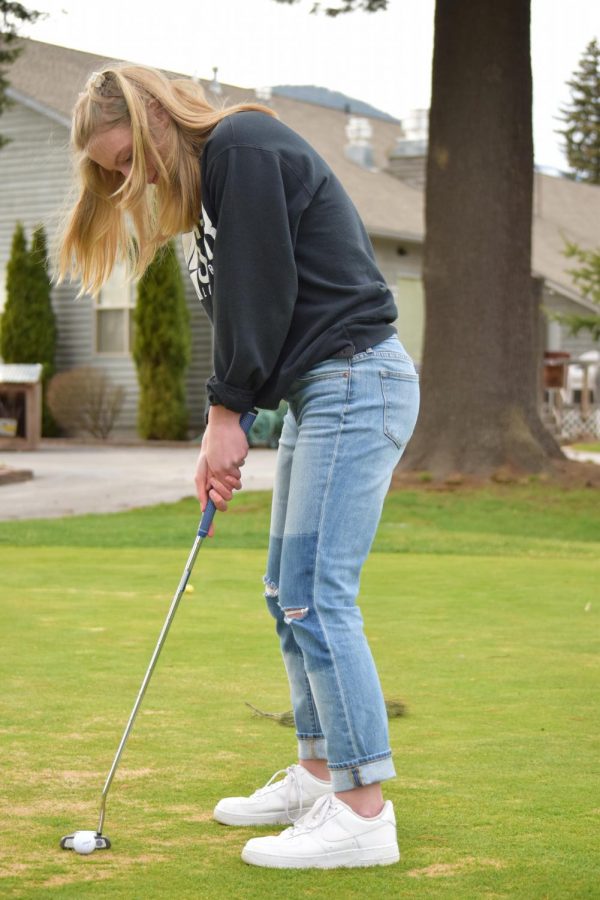 Junior Annaby Kanning attempts to putt the ball into the hole.
