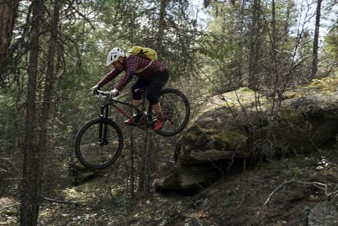  Ezra Stafford drops off a rock while braving a mountain biking trail.