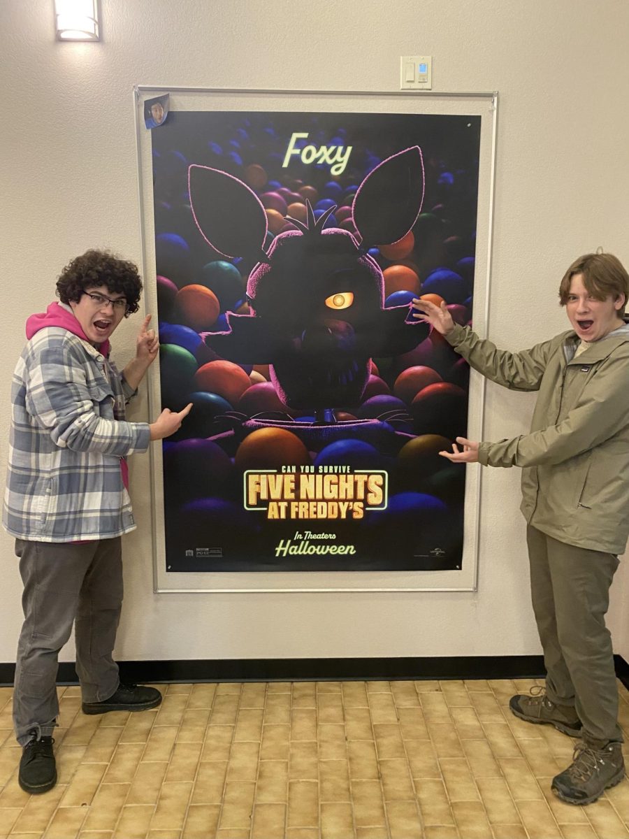 Staff Members William Clark and Matthew Norton pose next to the FNAF poster at the local Bonner County Movie Theater 