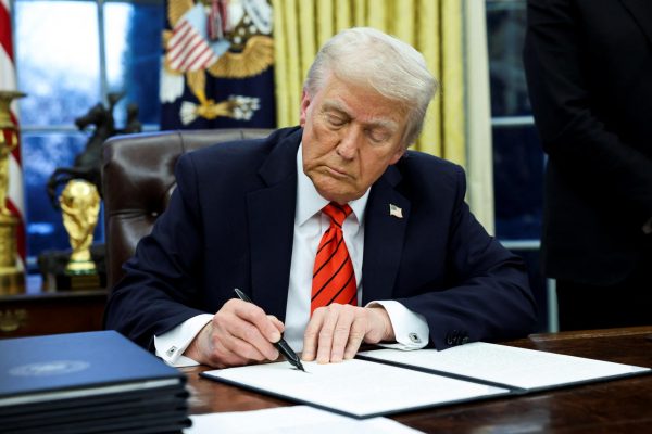 U.S. President Donald Trump signs an executive order in the Oval Office of the White House in Washington, U.S., February 10, 2025. REUTERS/Kevin Lamarque